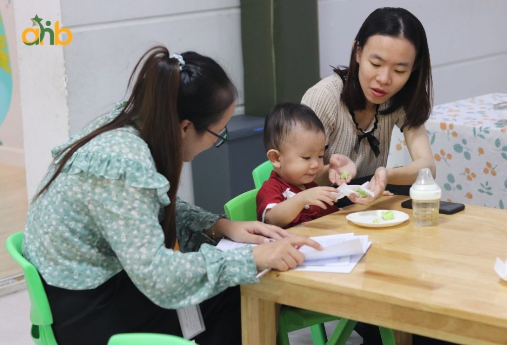 Giáo viên thực hiện đón trẻ và trao đổi nhanh với phụ huynh vào đầu giờ học